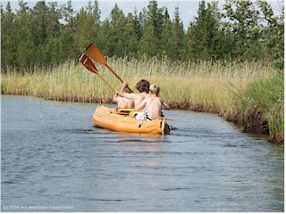 [ unsere kinder unterwegs im schlauchboot auf dem schilfgesumten flusslauf ]
