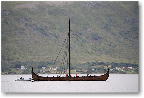 ein motorboot stoesst das vikingerboot des lofotr vikingmuseum