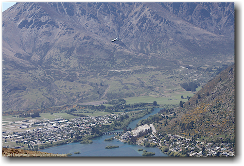 blick vom queenstown hill auf ein startendes flugzeug