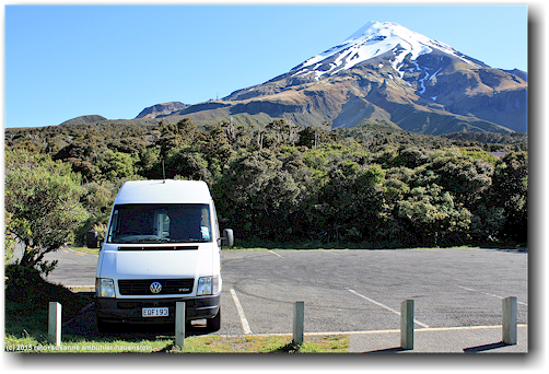 unser campervan auf dem parkplatz des taranaki visitor center north mit mount taranaki im hintergrund