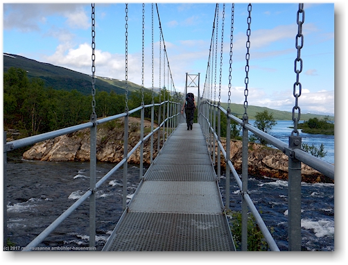 susanne auf der bruecke ueber den kamajakka entlang des kungsleden nahe der abiskojaurestugorna