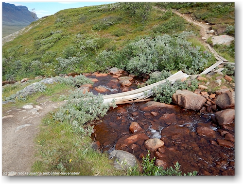 gebrochener steg entlang des kungsleden ueber einen kleinen zufluss zum autsutj-jakka