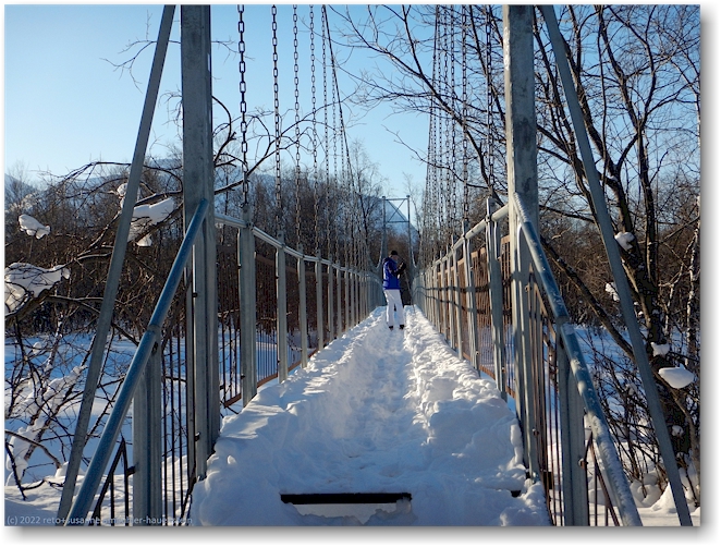 susanne auf der bruecke ueber den nissunjohka im verlauf des kungsleden