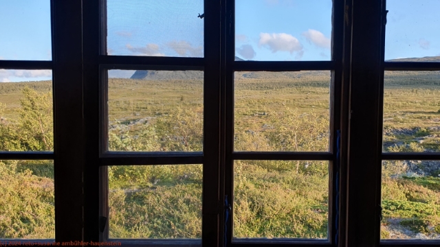 blick aus dem fenster der njunjes fjaellstuga auf einen beinahe wolkenlosen himmel