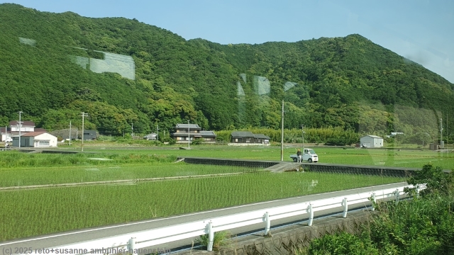 blick aus dem regionalzug auf die felder bei susami