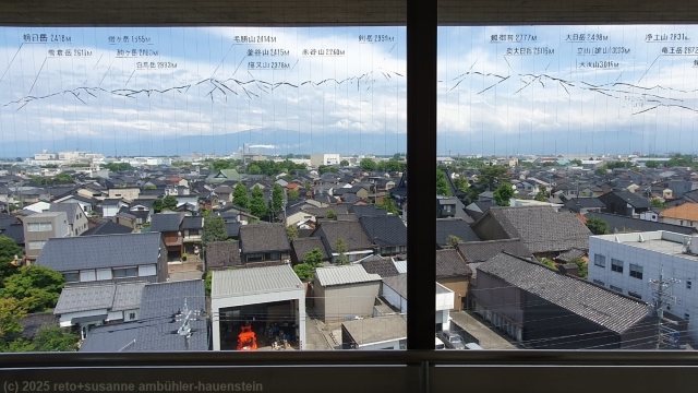 scheibe mit konturen der berge und hoehenangaben im toyama port observatory